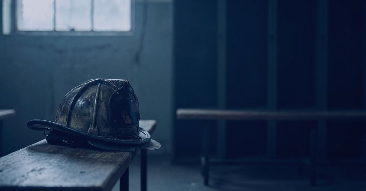A worn firefighter helmet resting on a bench in an empty room